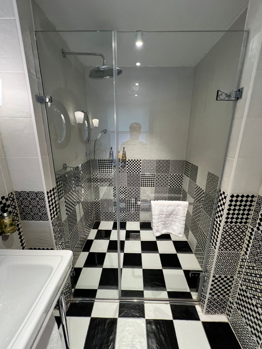Clear glass shower screen install in a tiled bathroom