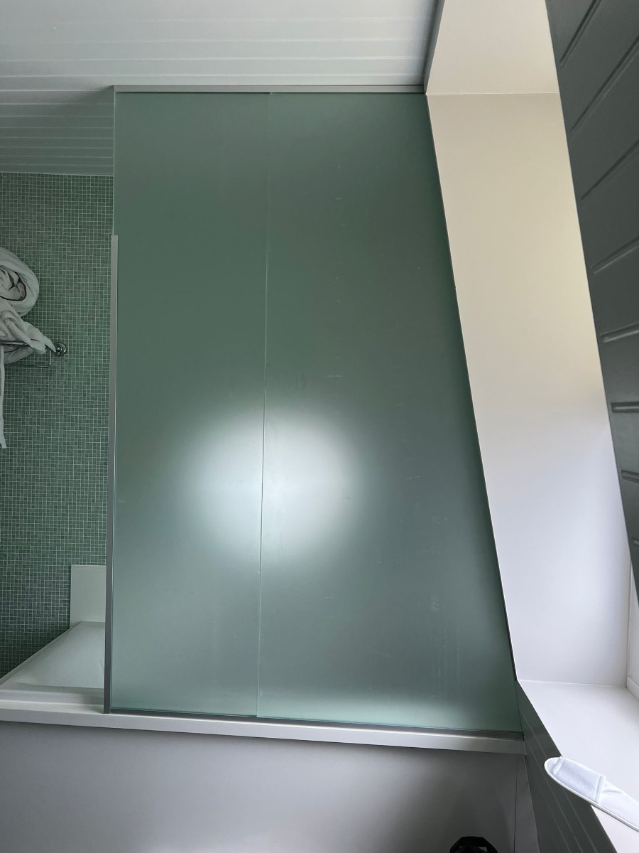 Frosted glass bathroom panel with soft natural light