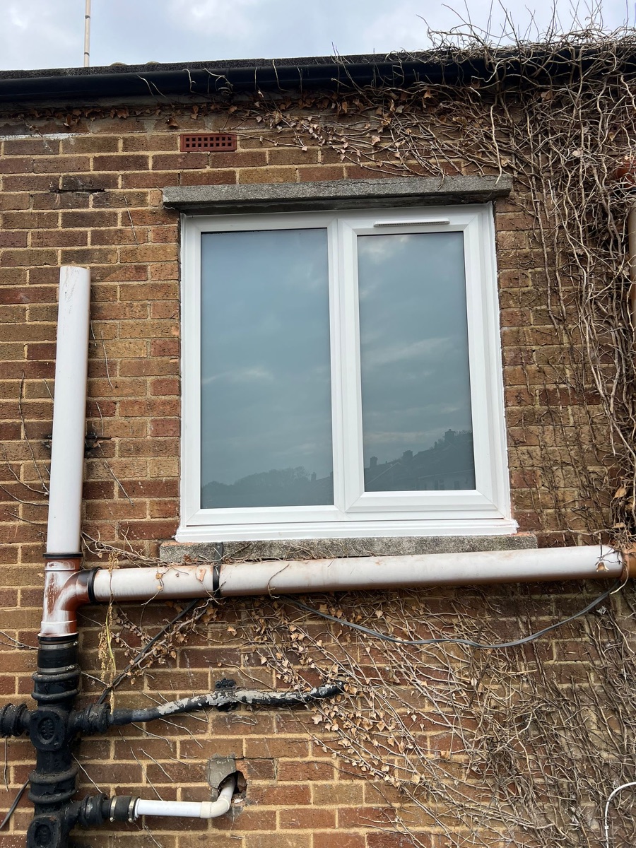 New UPVC double-glazed window installed in older brick wall